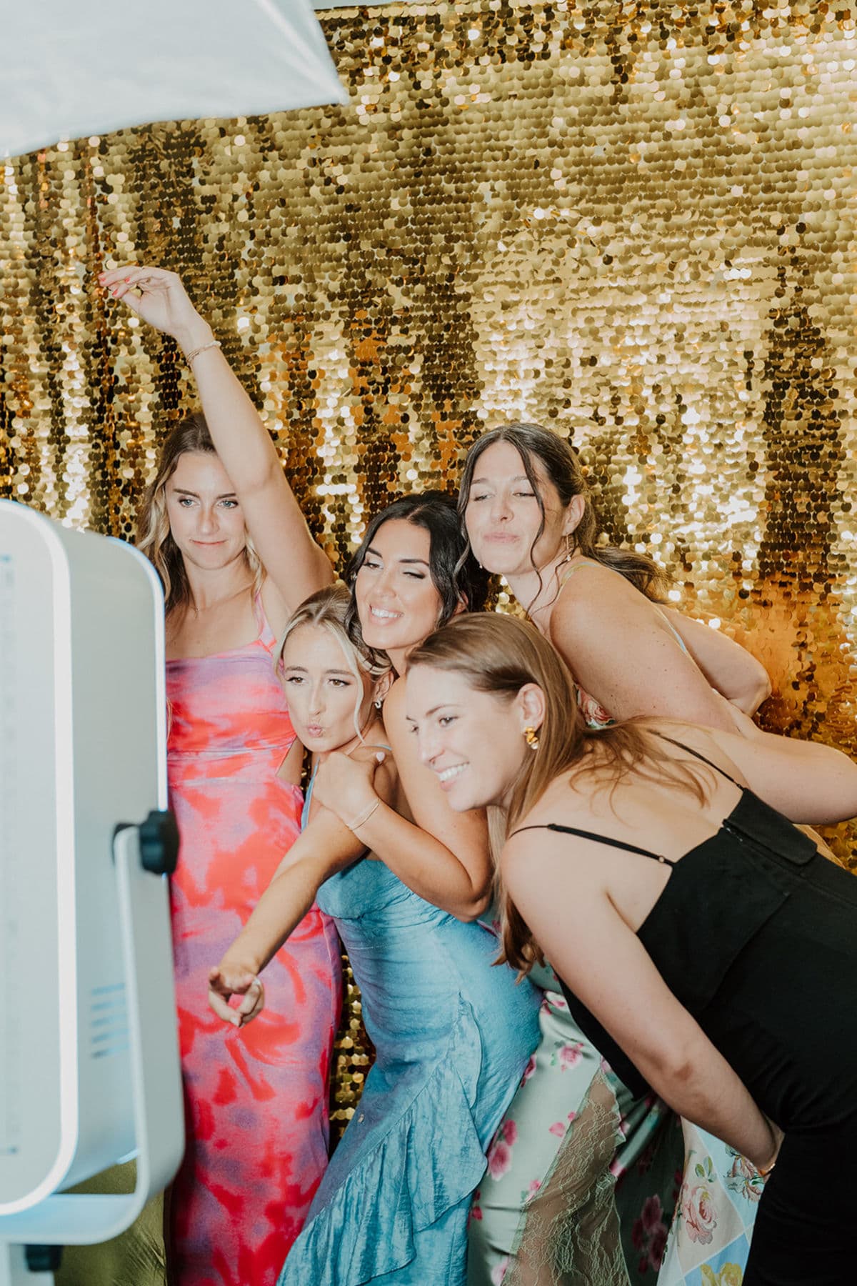 Bridesmaids piling into the photo booth